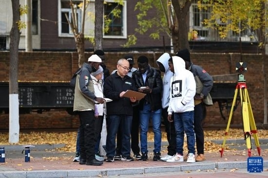在天津鐵道職業(yè)技術學院，老師指導幾內(nèi)亞學員使用測距儀器（11月11日攝）。新華社記者 李然 攝