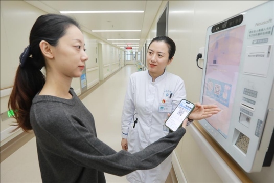 醫(yī)護人員引導患者在自助機前辦理自助入院手續(xù)。圖片來源：山東第一醫(yī)科大學第二附屬醫(yī)院