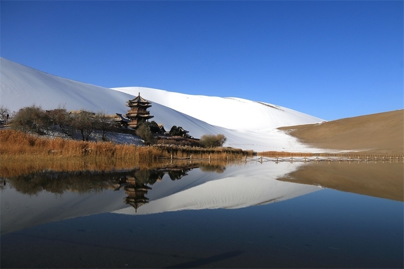 鳴沙山月牙泉景區(qū)雪景。敦煌市委宣傳部供圖，張曉亮攝