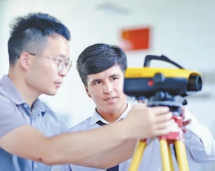 在塔吉克斯坦首都杜尚別的魯班工坊，來自天津城市建設(shè)管理職業(yè)技術(shù)學(xué)院的老師（左）為當(dāng)?shù)貙W(xué)生提供指導(dǎo)。新華社記者 鄭開君 攝