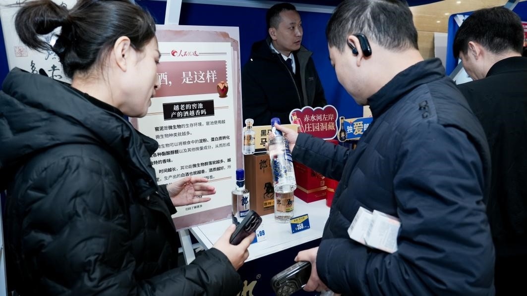 白酒展位負責人在為嘉賓介紹。張新攝