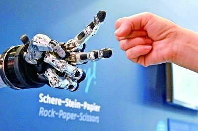 在德國(guó)漢諾威工博會(huì)上，參觀者與一款智能機(jī)器人進(jìn)行“石頭剪子布”游戲。新華社發(fā)