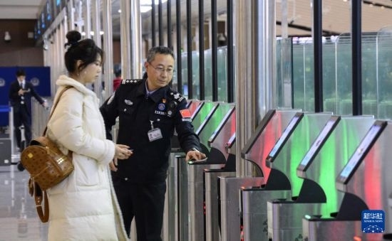 1月2日，大興機(jī)場邊檢站警察指導(dǎo)旅客使用自助出境設(shè)備。新華社記者 李欣 攝