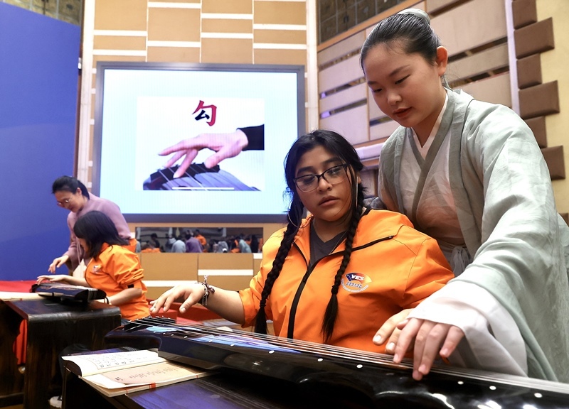 2024年3月20日，美國華盛頓州中學生代表團北京大學交流活動在北京大學英杰交流中心舉行。圖為來自華盛頓州的中學生體驗古琴。