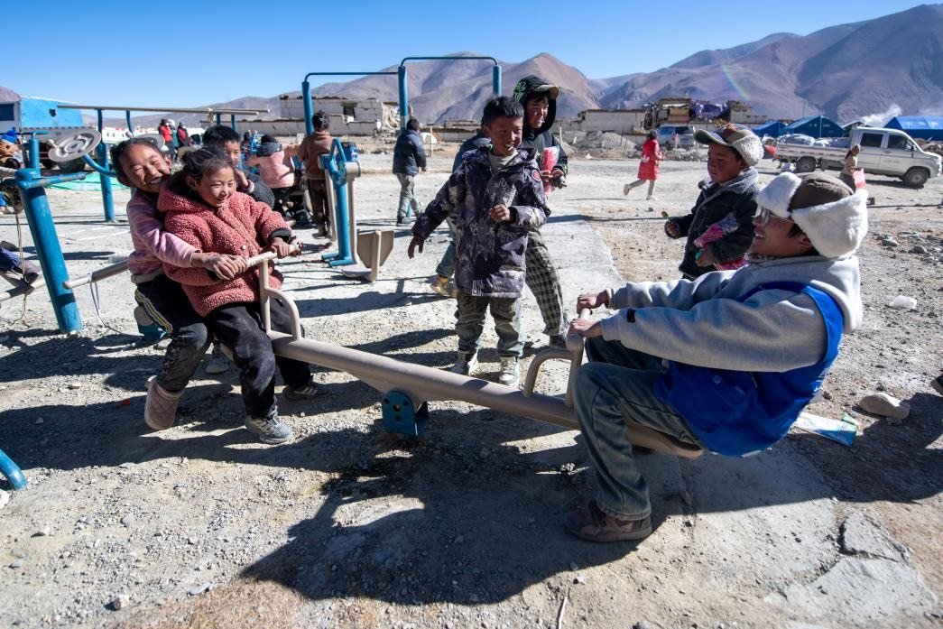 1月11日，在定日縣措果鄉(xiāng)塘仁村安置點(diǎn)，西藏星光社會(huì)工作服務(wù)中心志愿者和孩子們一起玩耍，進(jìn)行災(zāi)后心理疏導(dǎo)。人民網(wǎng)記者 翁奇羽攝