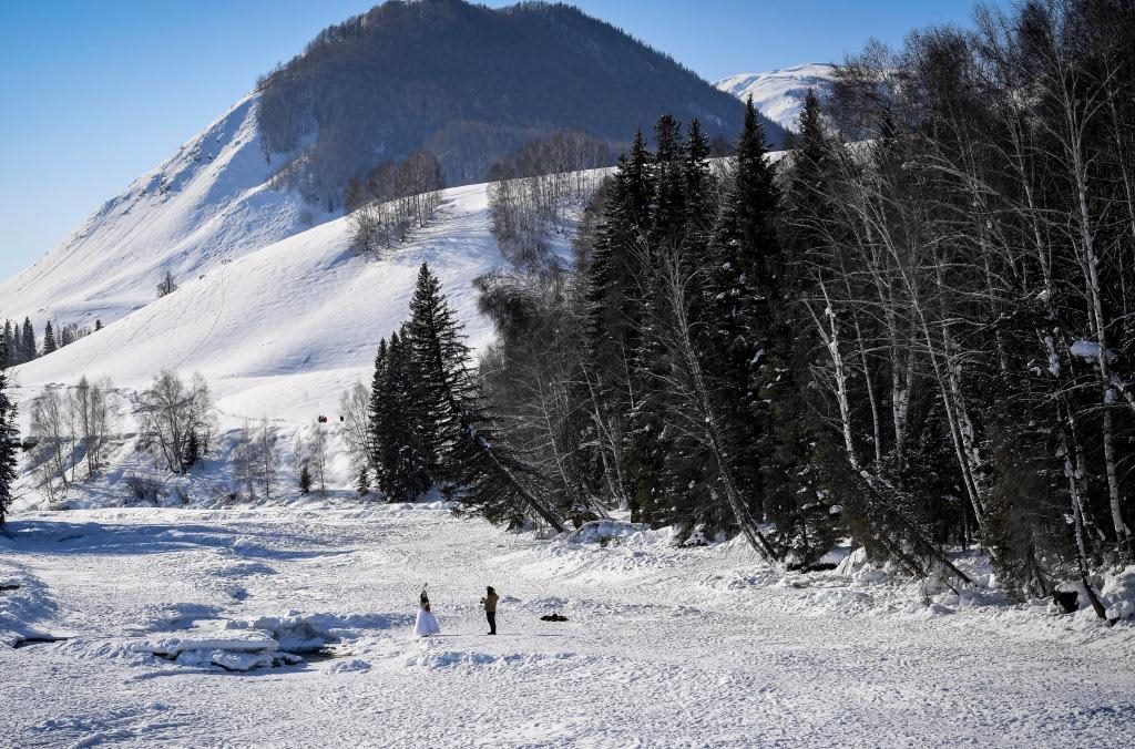 2024年2月5日，兩名游客在新疆阿勒泰地區(qū)布爾津縣禾木村拍照。新華社記者 馬鍇 攝