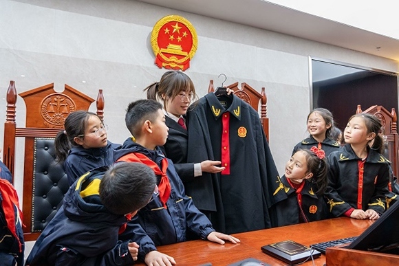 圖②：干警向同學們介紹法袍。