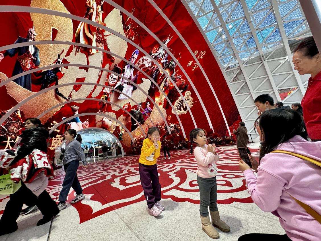 乙巳蛇年春節(jié)期間，影迷在《哪吒之魔童鬧海》巨幅海報前拍照打卡。