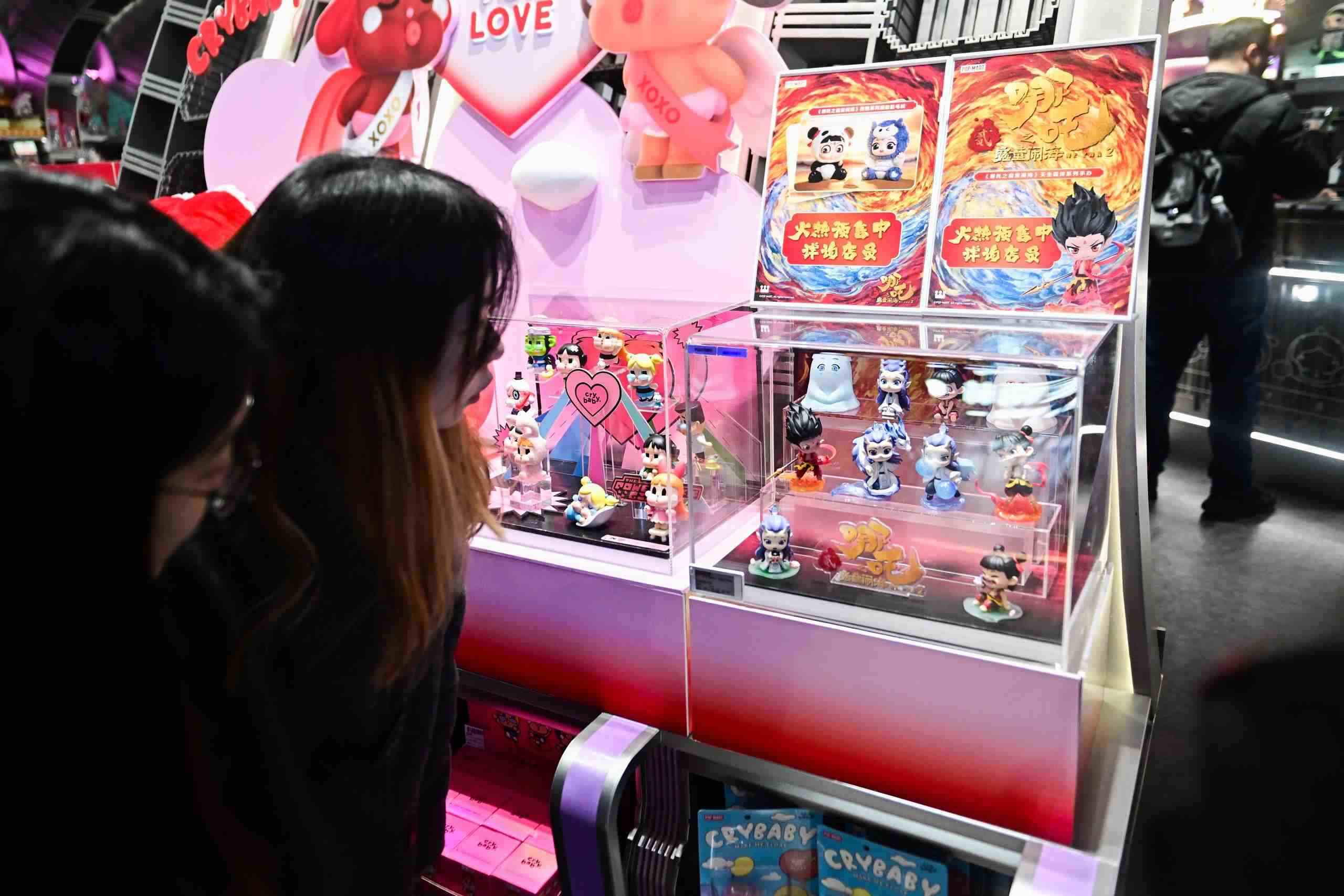 △2025年2月22日，上海，市民在圍觀《哪吒之魔童鬧?！废嚓P(guān)手辦盲盒。