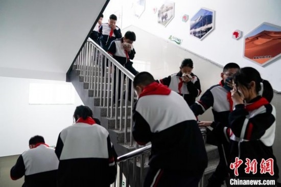  圖為學(xué)生們進(jìn)行應(yīng)急疏散演練。中新社記者 趙宇航 攝