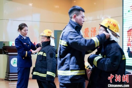 圖為學(xué)生們現(xiàn)場穿戴消防頭盔和戰(zhàn)斗服。中新社記者 趙宇航 攝