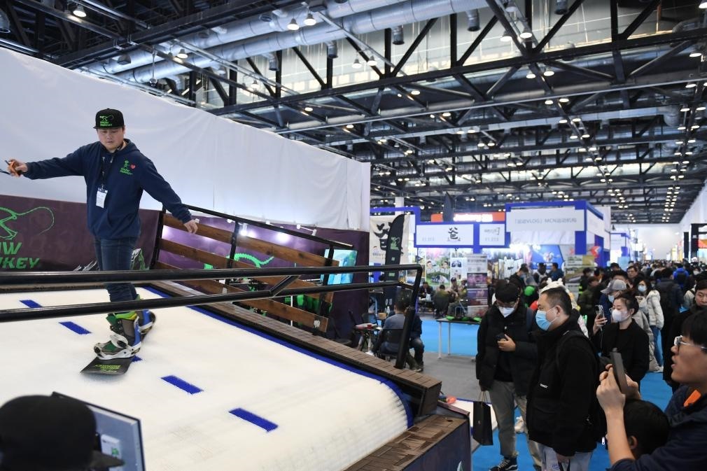 2023年2月11日，參觀者在展會上了解一款模擬滑雪設(shè)備。當(dāng)日，2023亞洲運動用品與時尚展在國家會議中心拉開帷幕。新華社記者 張晨霖 攝