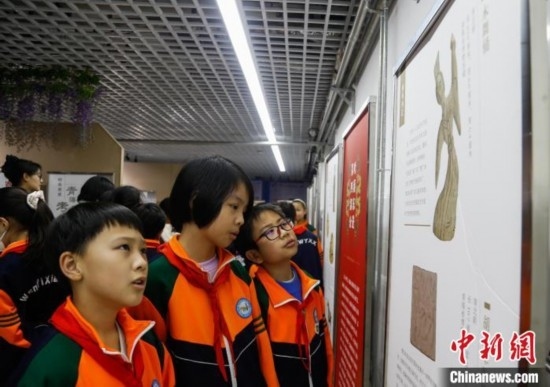 圖為學生參觀青海省博物館“1+3”主題流動展覽，了解木舞俑。中新社記者 馬銘言 攝