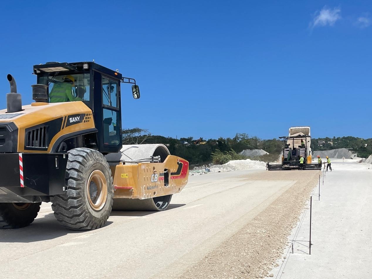 圖為中企承建的牙買(mǎi)加蒙特哥貝繞城路項(xiàng)目基層試驗(yàn)段正在進(jìn)行攤鋪和碾壓施工，相關(guān)施工工作已于日前順利完成。中國(guó)港灣美洲區(qū)域公司供圖