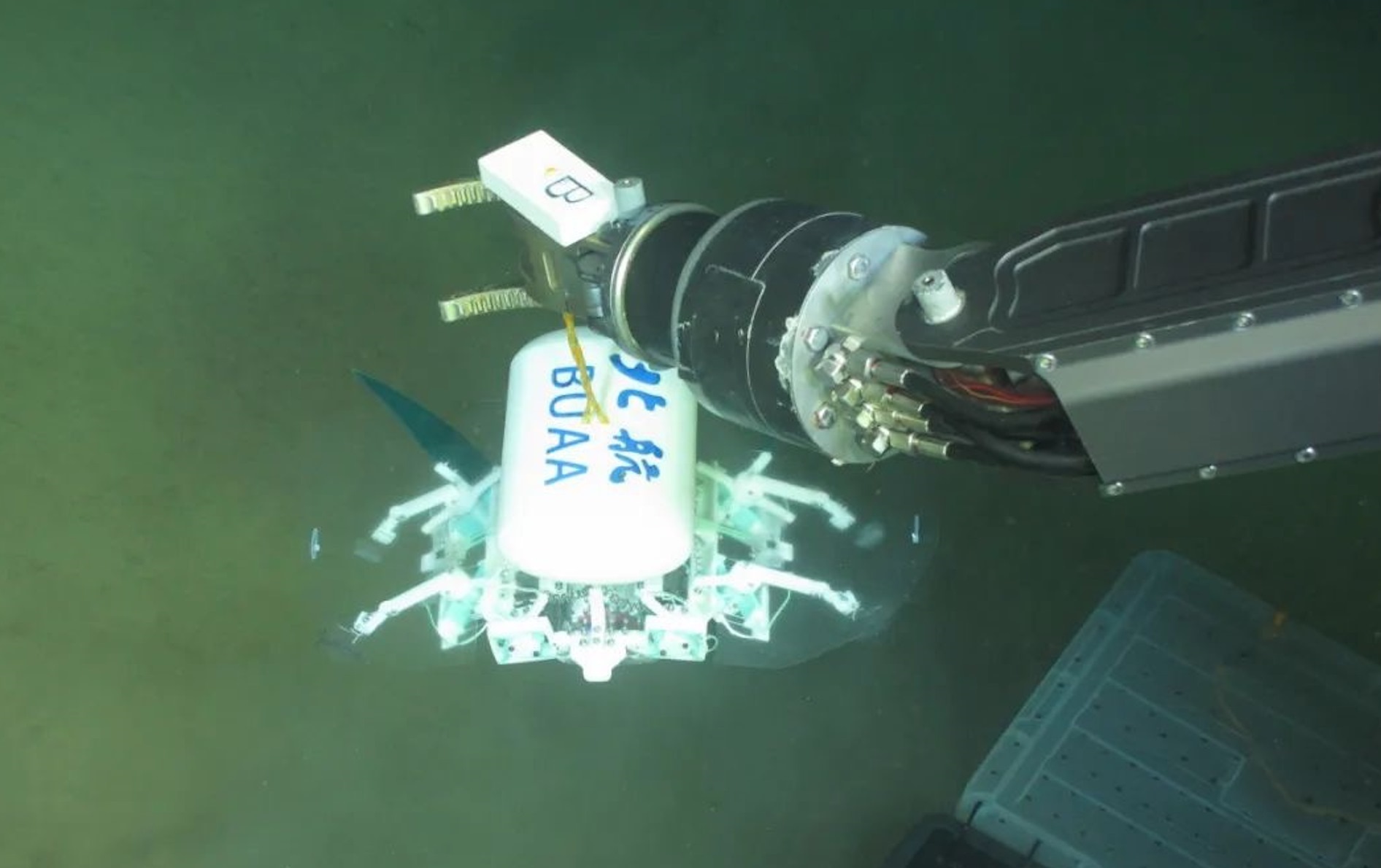 科研人員利用機(jī)械臂將北航深海小型機(jī)器人投于馬里亞納海溝。校方供圖