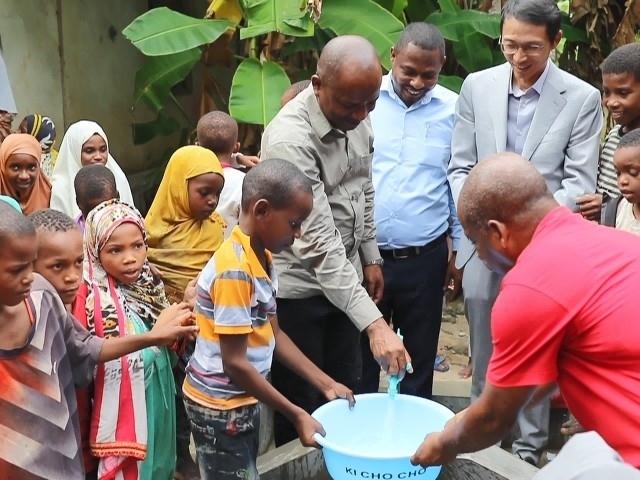 在日前舉行的安全供水工程揭牌儀式上，當(dāng)?shù)匦∨笥言诠┧c(diǎn)接水。 施亮攝