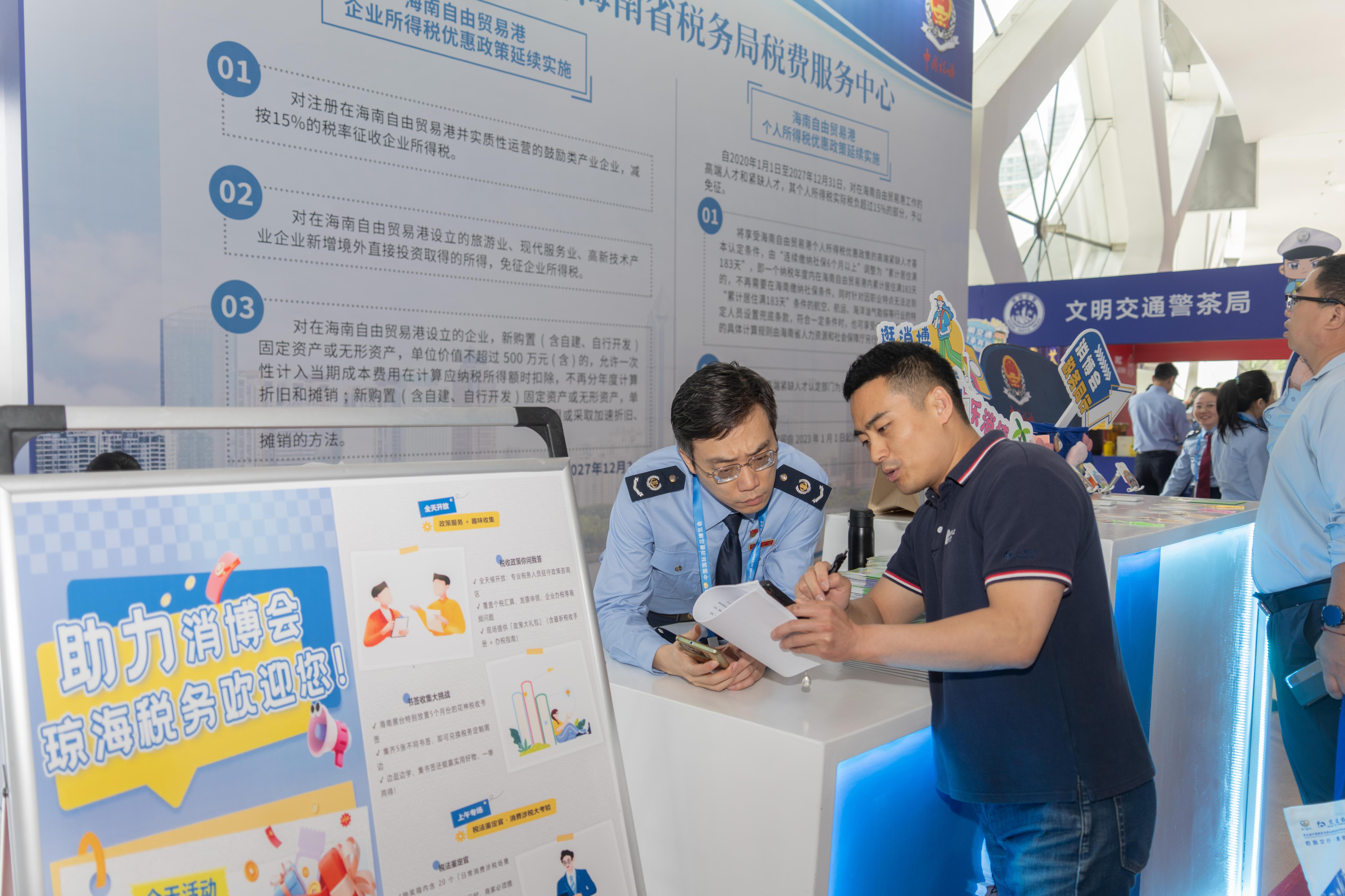 稅務(wù)服務(wù)臺(tái)工作人員向記者介紹服務(wù)參展外商的具體舉措。人民網(wǎng)記者 許崢攝