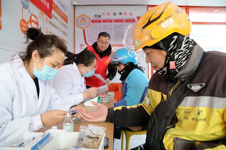 2025年3月5日，志愿者在山東省棗莊市市中區(qū)一工會(huì)驛站為外賣員免費(fèi)測(cè)量血糖。新華社發(fā)（王海楠攝）