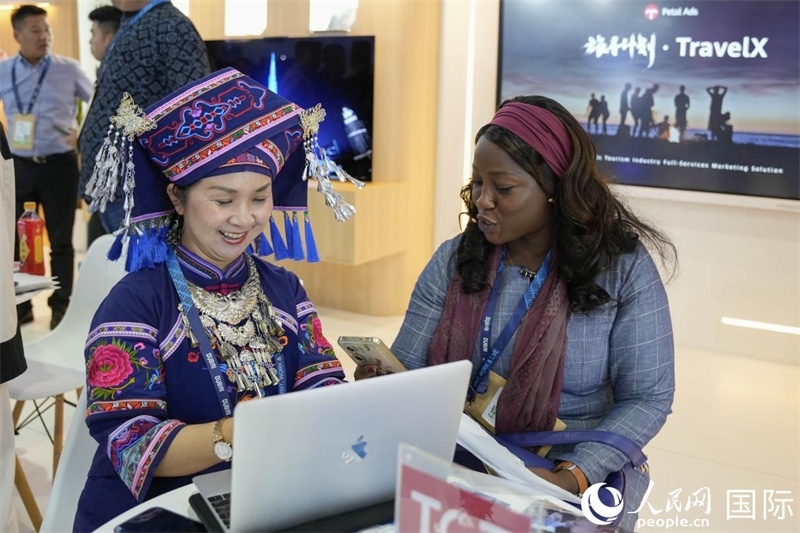 來(lái)自廣西的旅游業(yè)者同客戶交流。人民網(wǎng)塔里克·易卜拉欣攝