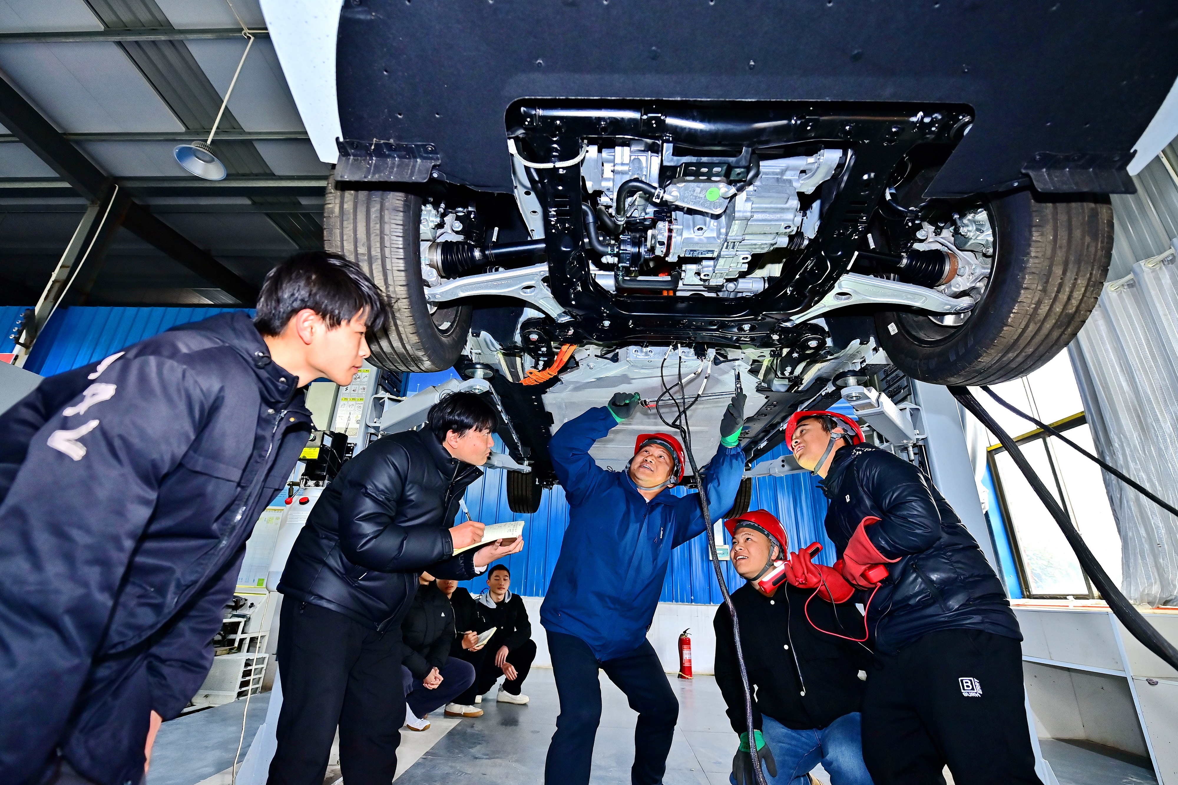 2025年2月，江西省宜春市，豐城市的一所技工學校實訓基地內(nèi)，新能源汽車運維專業(yè)學生在老師的指導下學習新能源汽車電池包檢修技術。