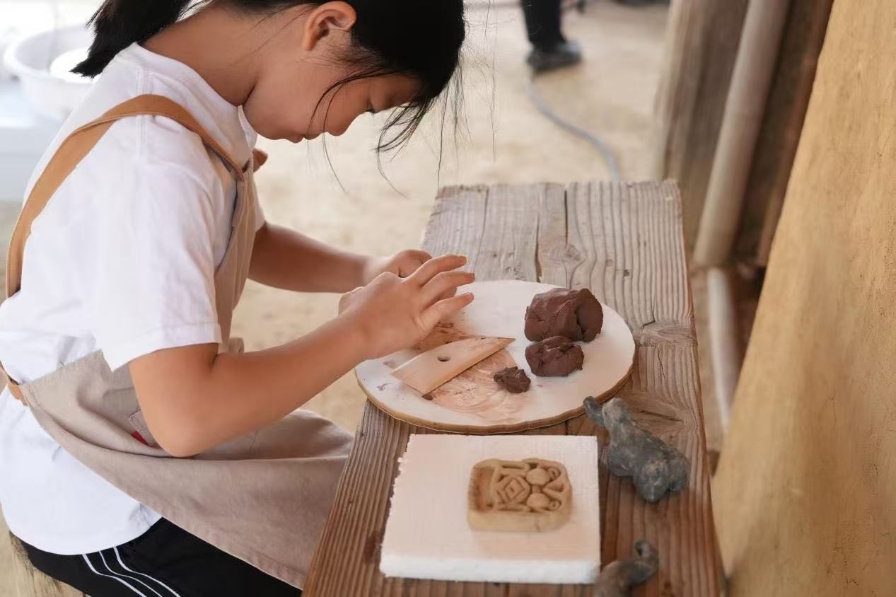 游客制作良渚特色陶藝品。良渚博物院供圖