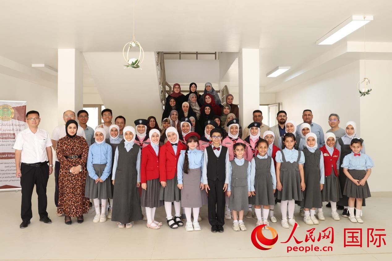 中國電建員工與阿爾穆塔?阿里卡特國際學(xué)校的師生及政府官員等合影。人民網(wǎng)記者 薛丹攝