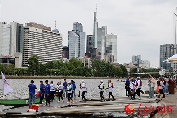 來(lái)自美國(guó)的快樂(lè)龍舟隊(duì)選手們正在登船準(zhǔn)備參賽。人民網(wǎng)記者 劉仲華攝
