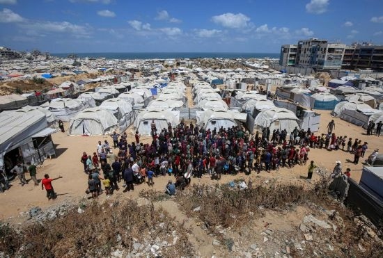 5月28日，人們在加沙城西部的沙提難民營等待領(lǐng)取救助食物。新華社發(fā)（里澤克·阿卜杜勒賈瓦德攝）