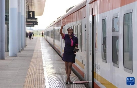 5月31日，在蒙內(nèi)鐵路內(nèi)羅畢站，一名乘務(wù)員在即將開往蒙巴薩的E2次列車旁等候乘客。新華社記者 李亞輝 攝