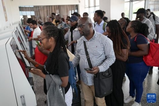 5月31日，在蒙內(nèi)鐵路內(nèi)羅畢站，乘客在自助取票機(jī)前排隊(duì)取票。新華社記者 楊光 攝