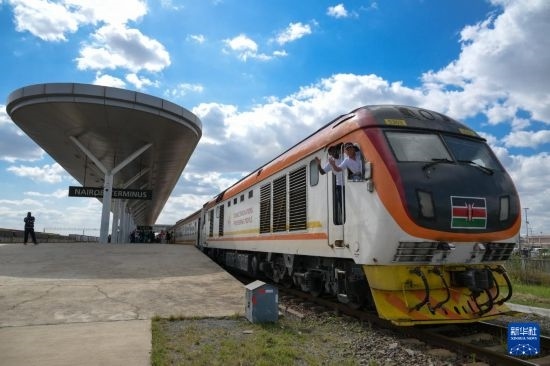 5月31日，在蒙內(nèi)鐵路內(nèi)羅畢站，機(jī)車駕駛員蔣立平（右）和博爾在即將開往蒙巴薩的E2次列車上揮手致意。新華社記者 楊光 攝