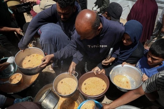 5月28日，人們在加沙城西部的沙提難民營領(lǐng)取救助食物。新華社發(fā)（里澤克·阿卜杜勒賈瓦德攝）